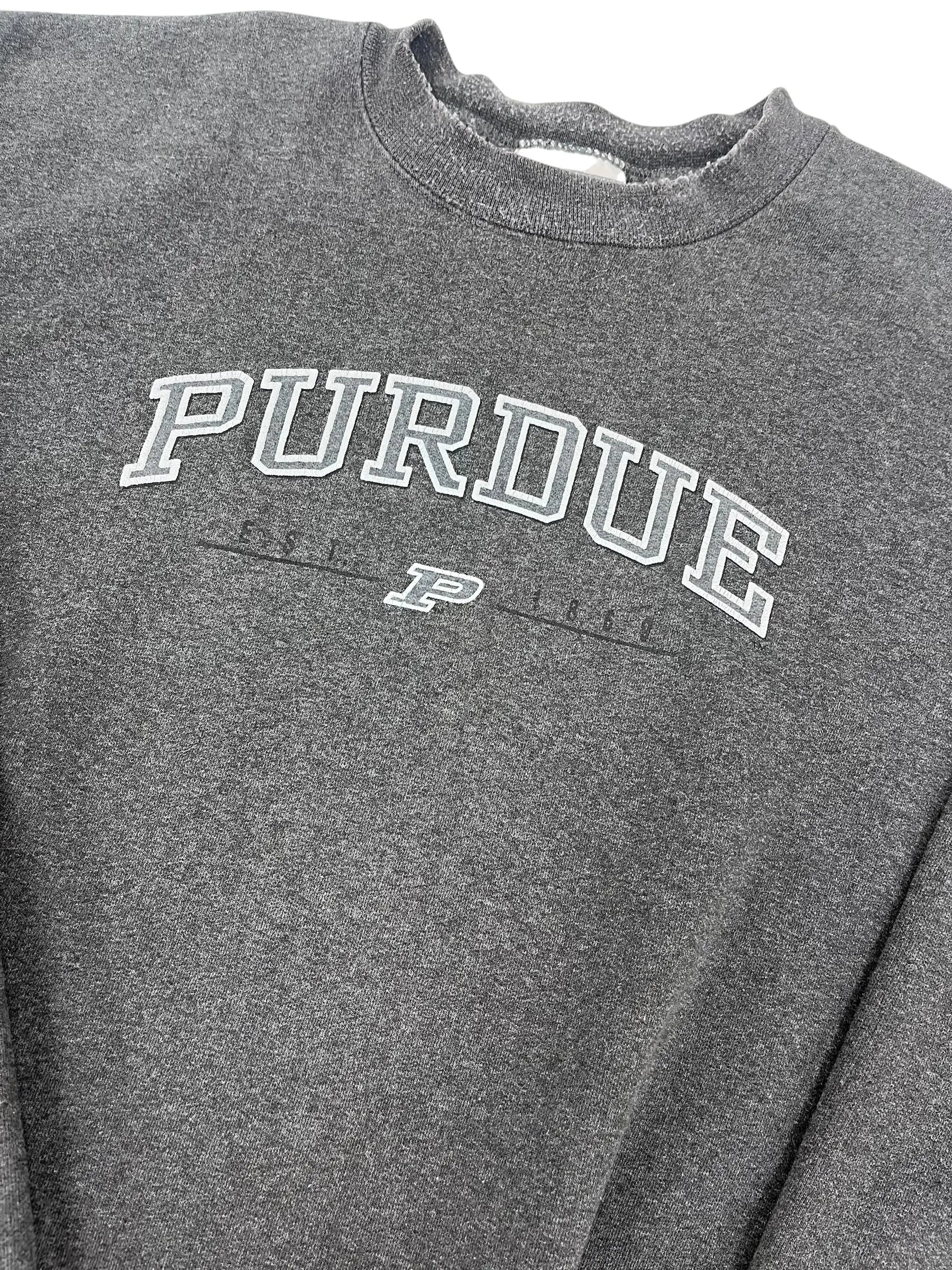 Close-up of a dark heather gray t-shirt featuring a white and gray 'PURDUE' graphic printed vertically on the chest.